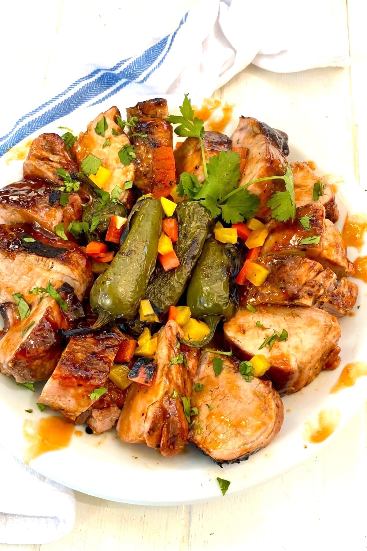 pork on a plate with peppers.