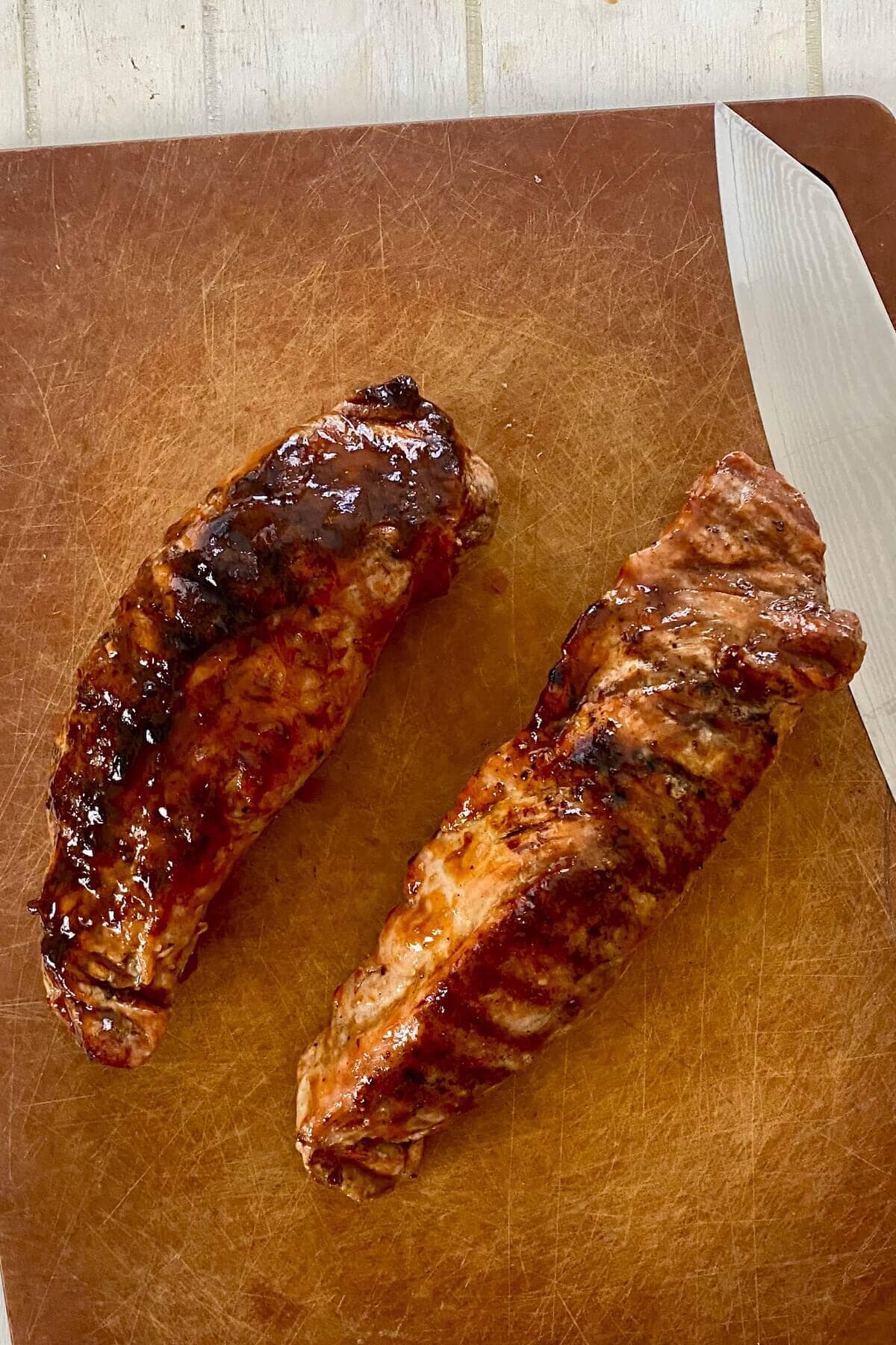 grilled and glazed pork tenderloin on a cutting board.