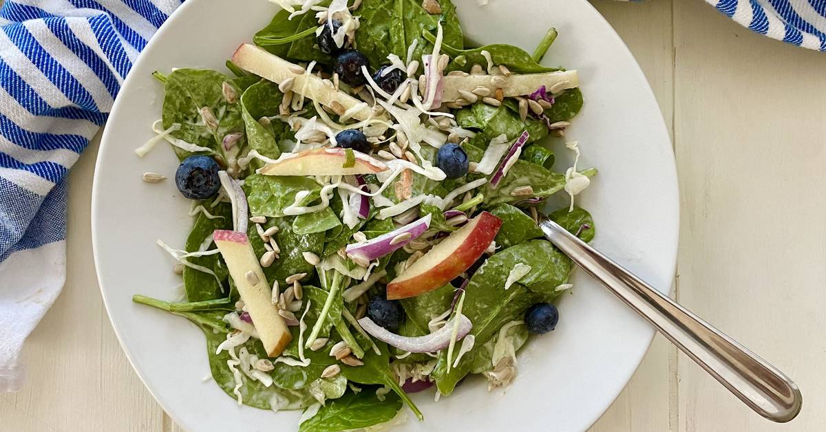 a salad with spinach and blueberries