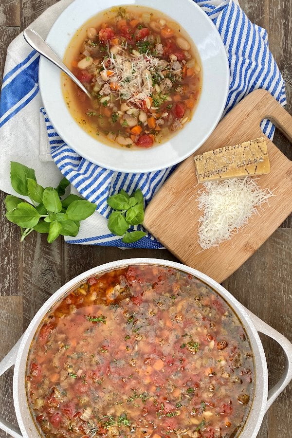 bowl and pot of pasta soup with Italian sausage and vegetables