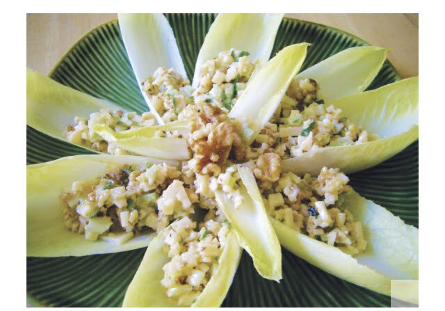 Endive leaves stuffed with walnuts and parmesan on a green plate.