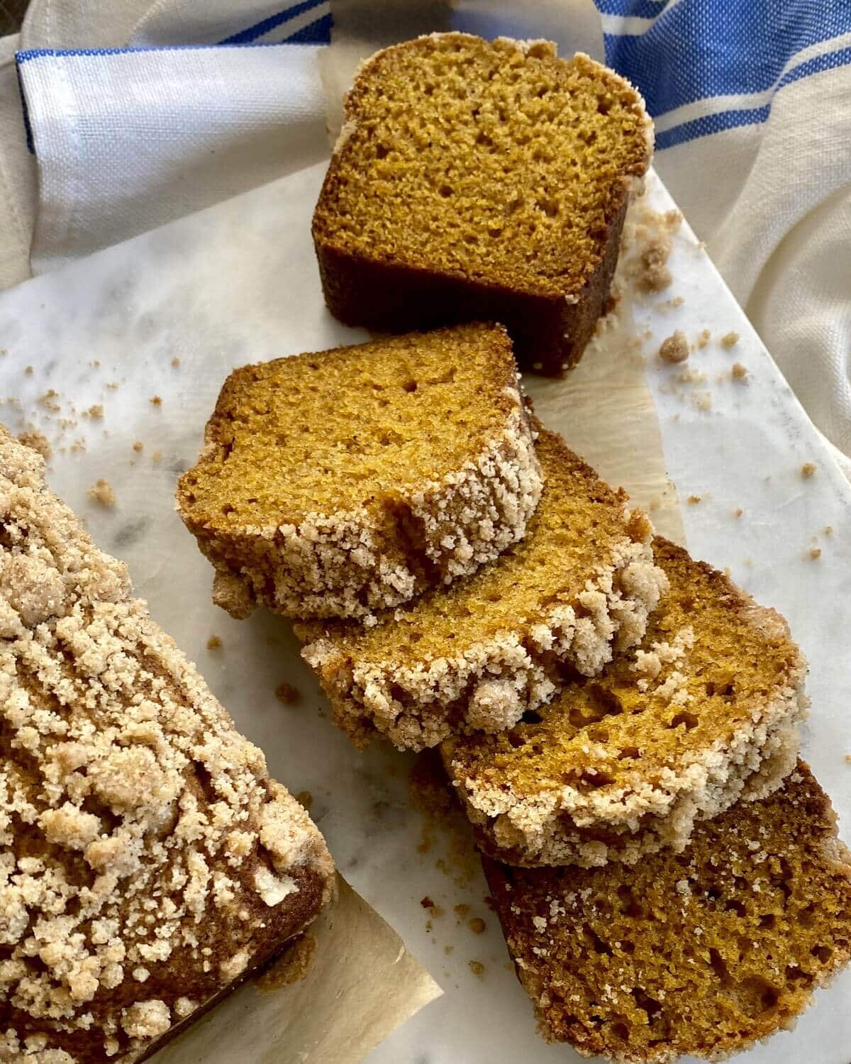 Pumpkin bread mini loaves sliced and on a marble board.