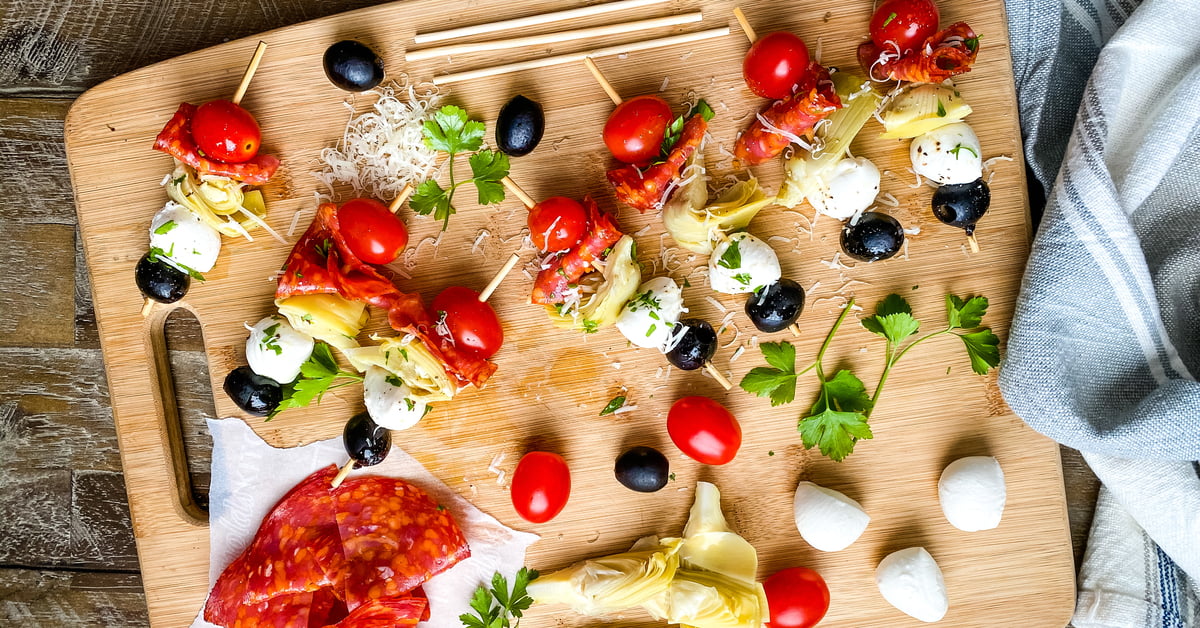 bamboo sticks with tomato, mozzarella, artichokes, salami and olives