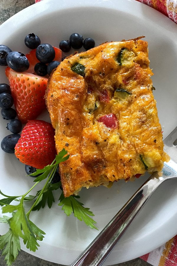egg dish with ham, onion, red pepper, zucchini and cheddar cheese
