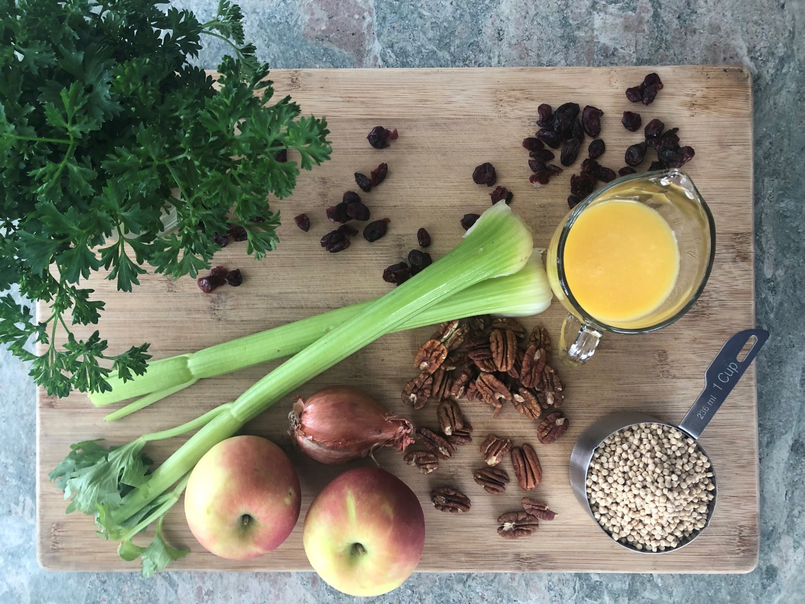 ingredients for recipe including couscous, orange juice, celery, apples, craisins and pecans