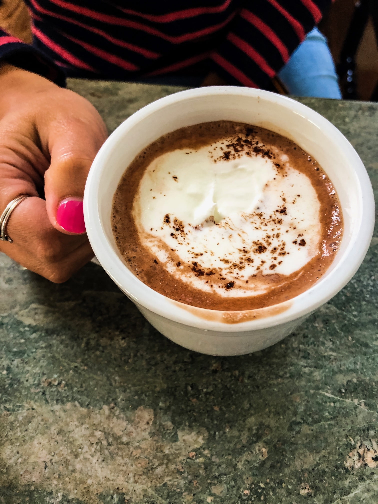 woman holding mug of hot cocoa with homemade whipped cream