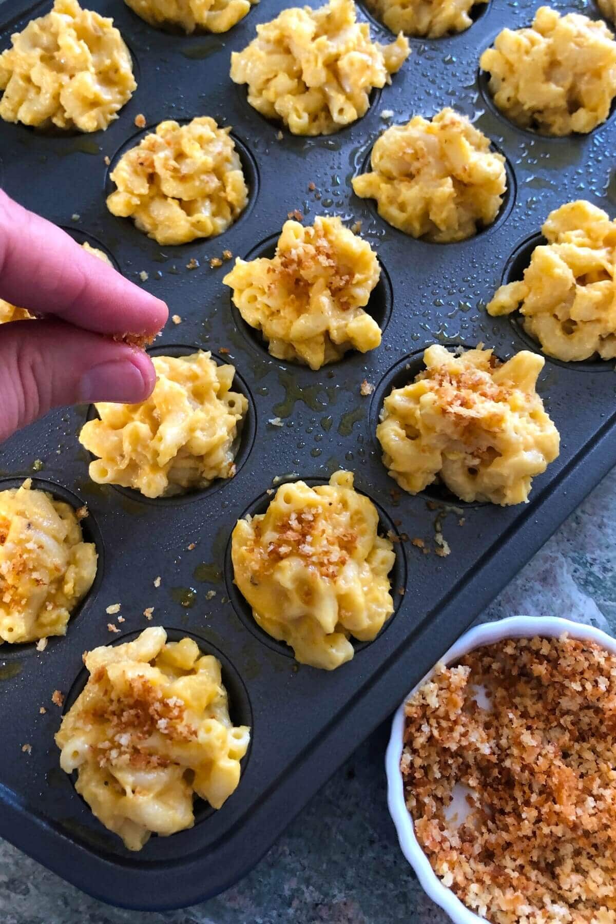 adding toasted panko to mini mac and cheese bites.