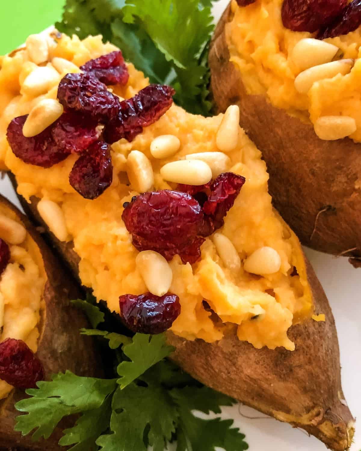 baked and stuffed sweet potatoes topped with pine nuts and dried cranberries