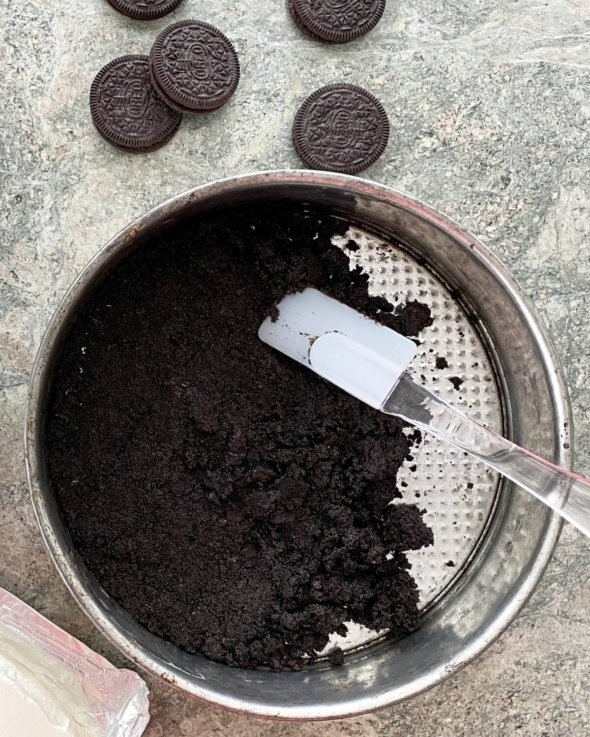 Pressing Oreo crust into a springform pan.
