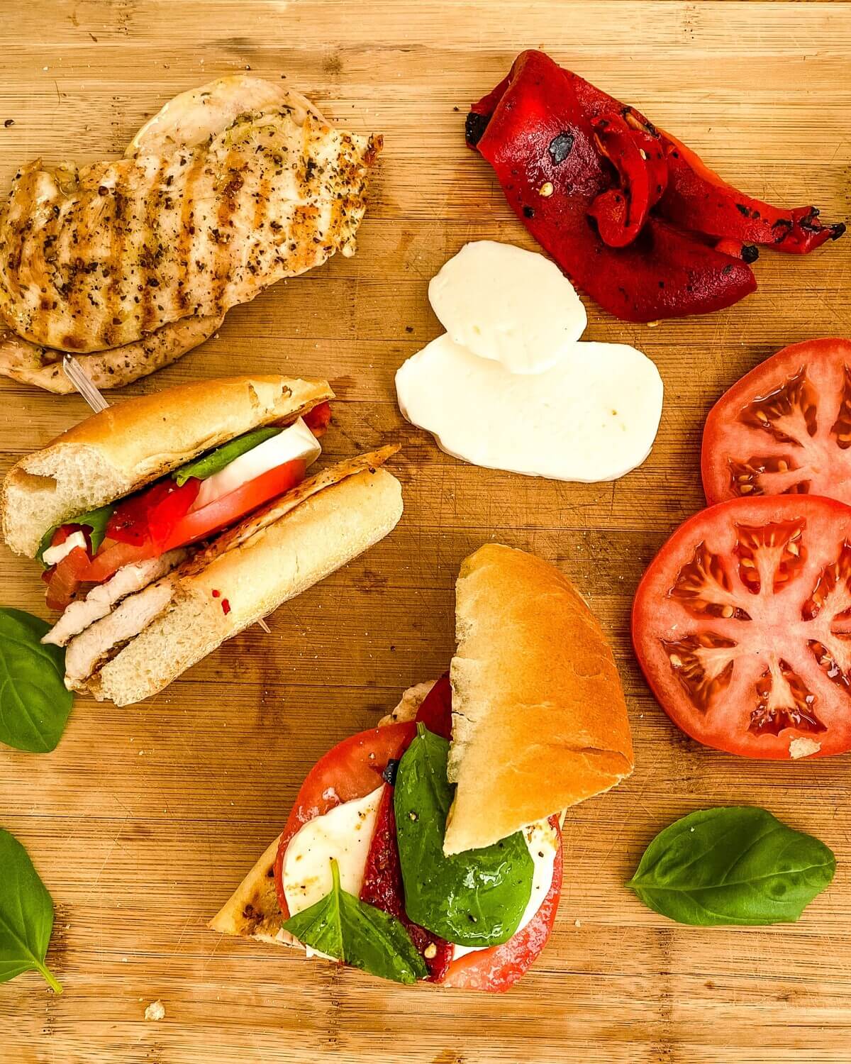 Grilled chicken, mozzarella, sliced tomato on a cutting board.