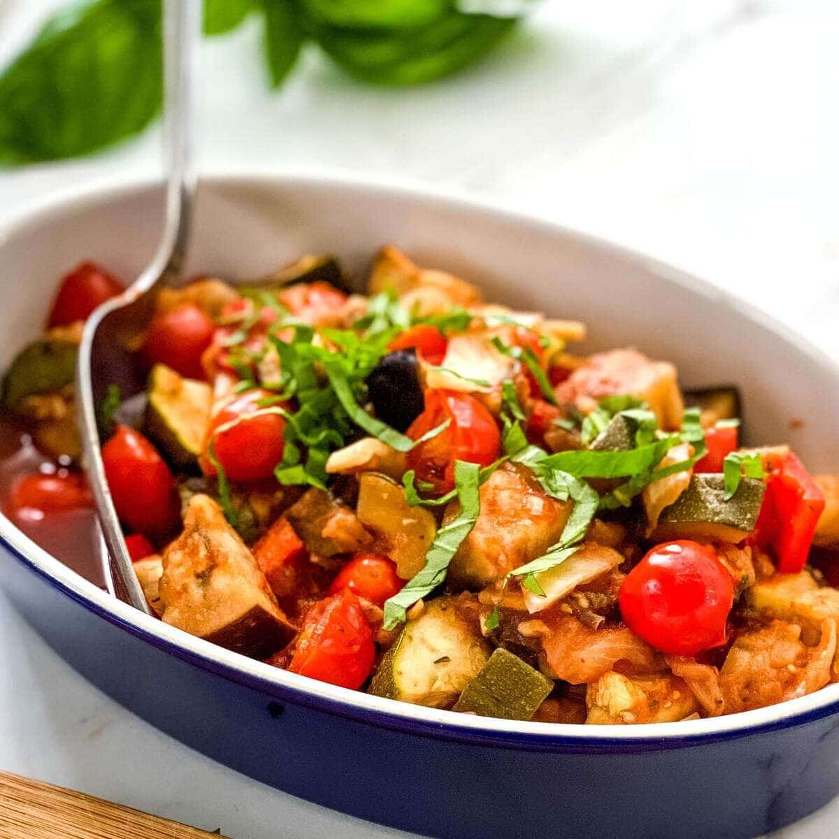 Serving dish with ratatouille and a serving spoon.