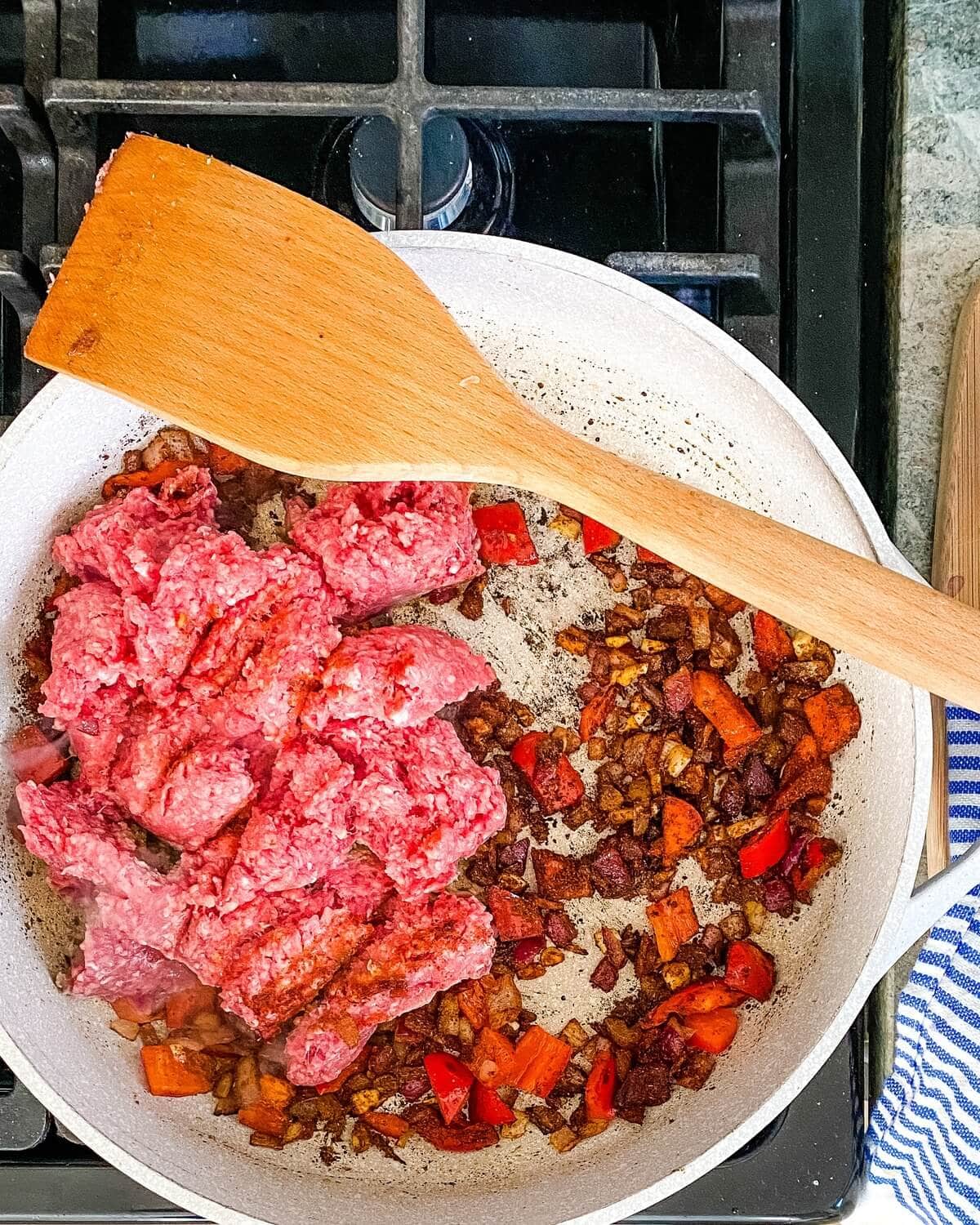 Ground beef added to the pot to brown.