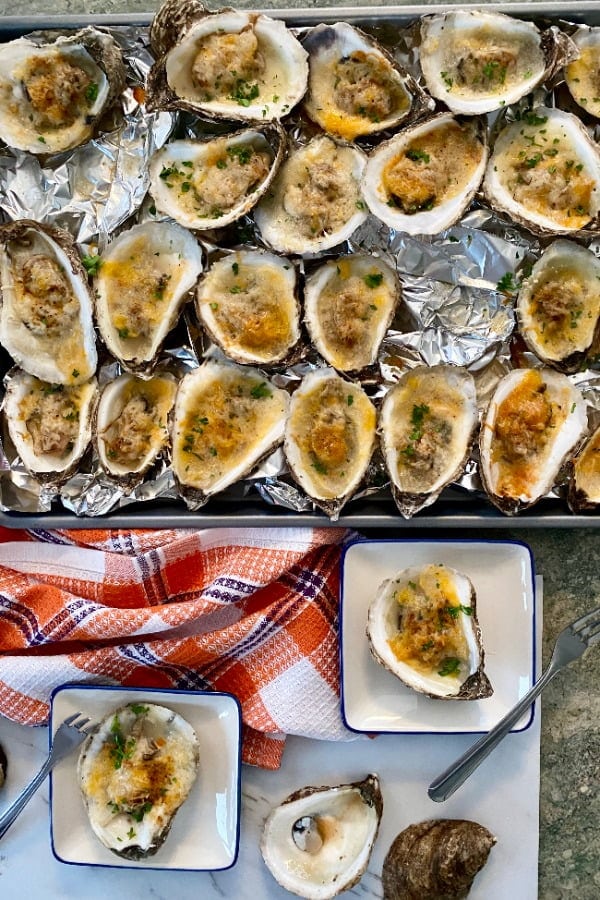 baking sheet with baked oysters with cheese