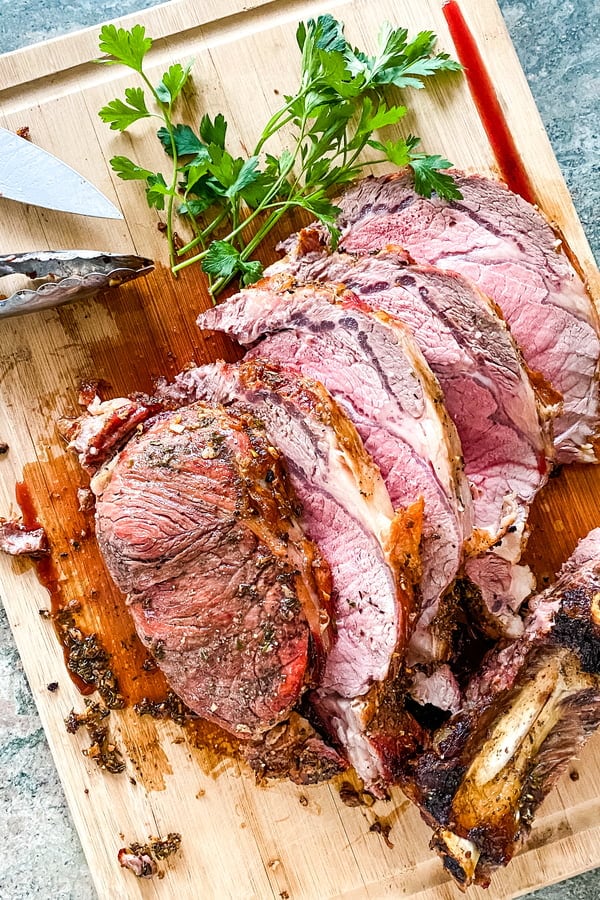 sliced slow roasted prime rib on a cutting board.