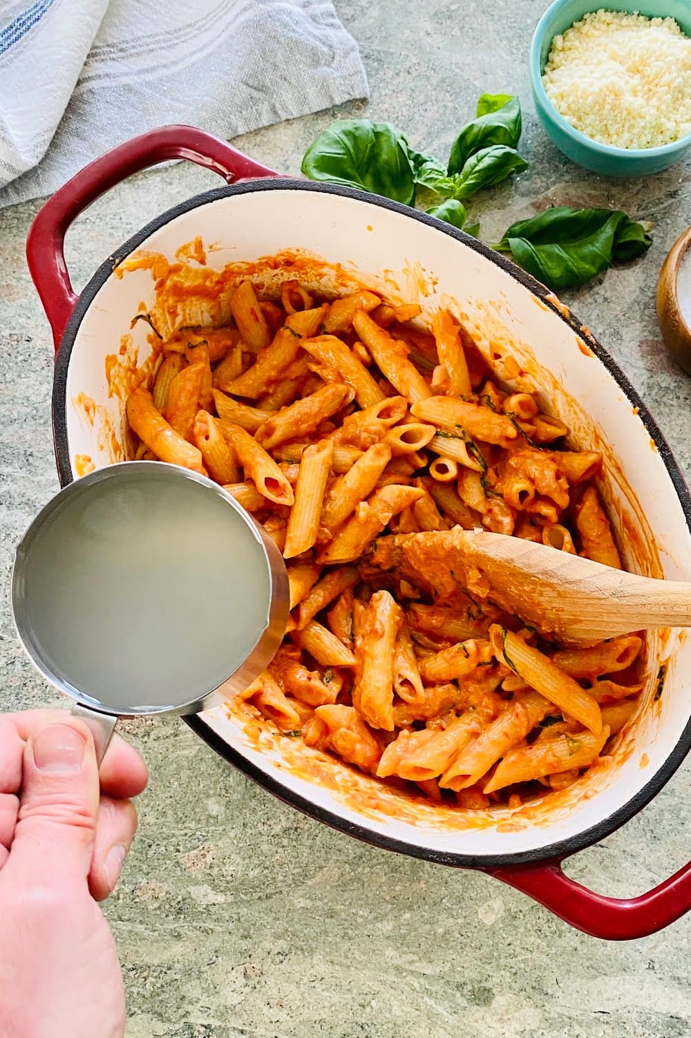 Adding pasta water to pasta to make it extra silky.