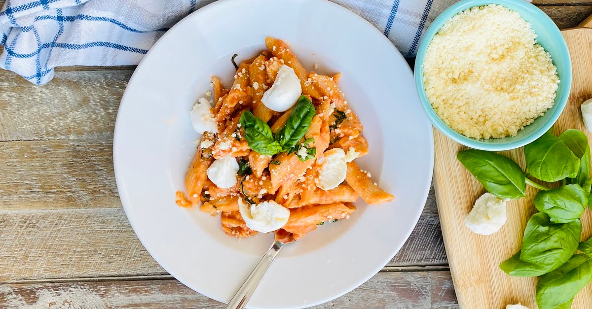 bowl of pasta with a creamy tomato sauce and fresh mozzarella