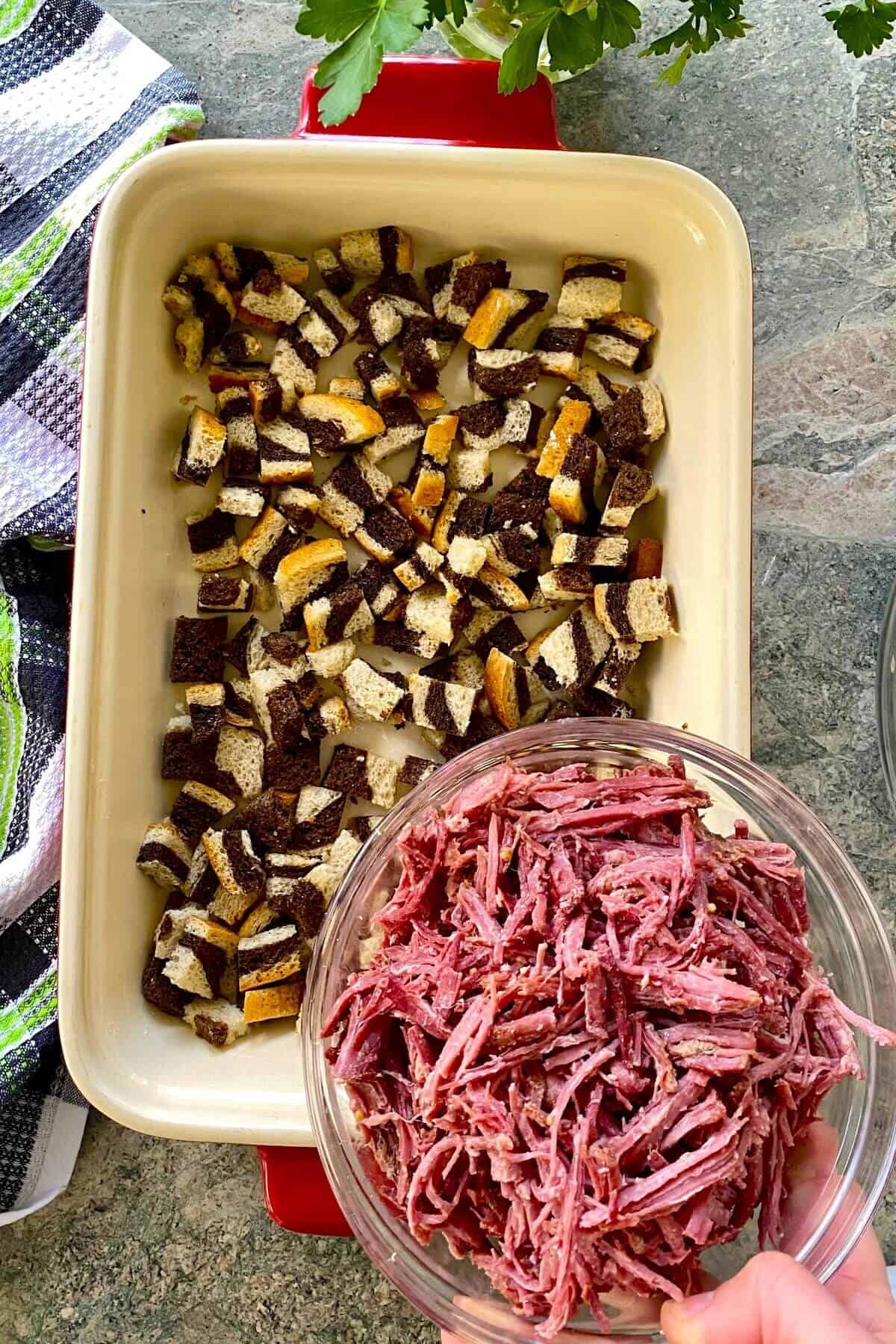 Adding corned beef to reuben casserole.