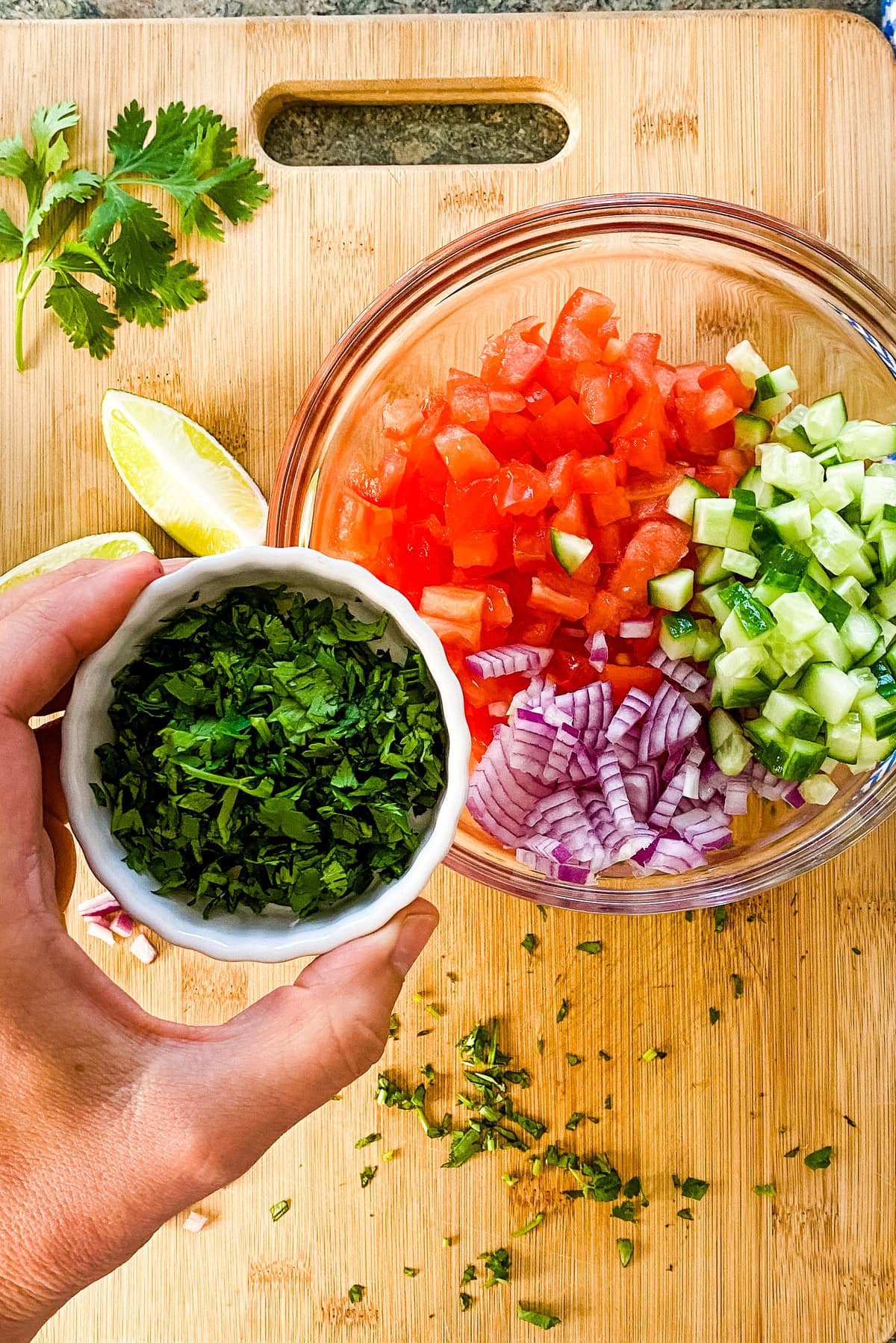 Adding herbs to salsa.