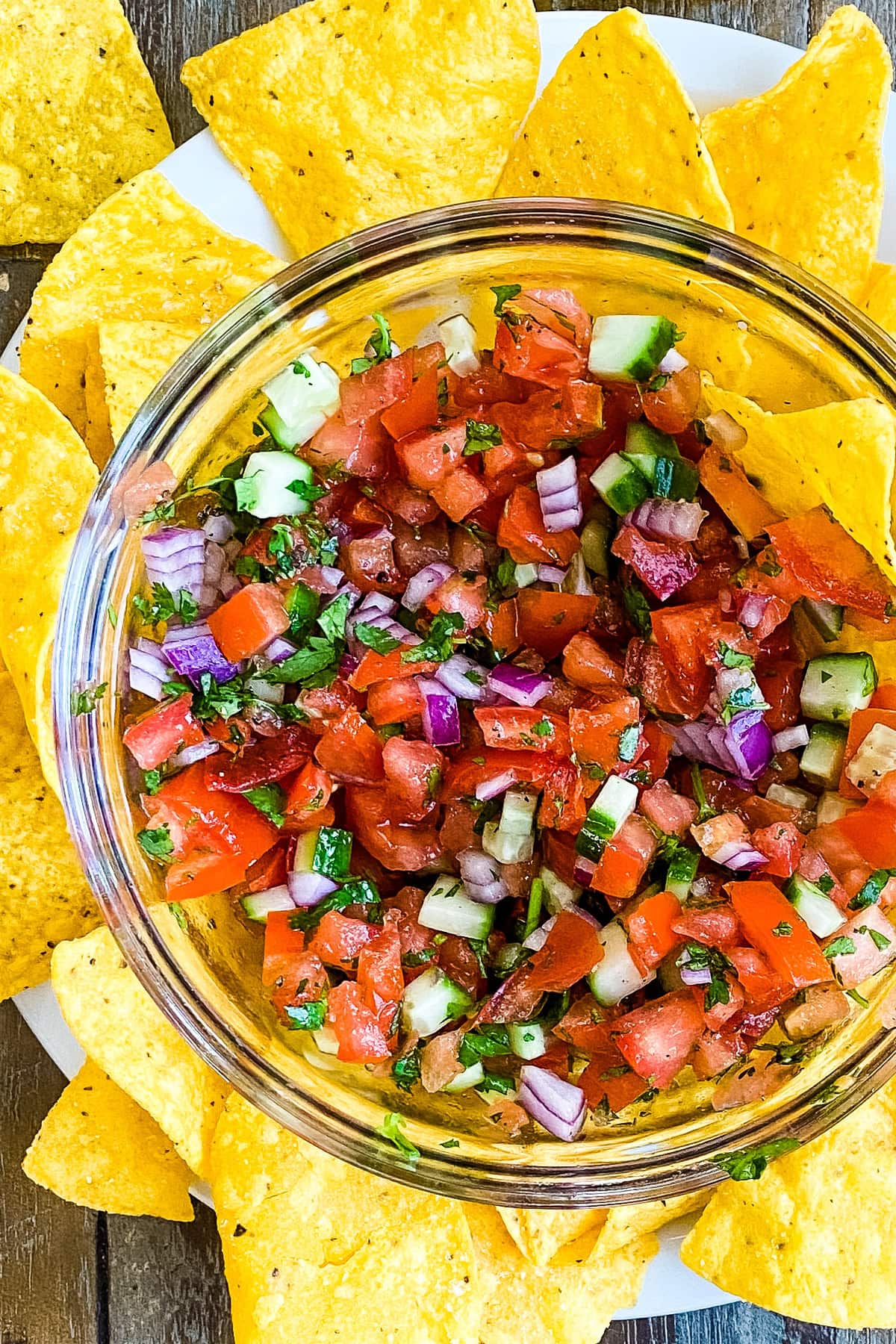An easy Pico de Gallo recipe with a bowl of chopped tomatoes, cucumbers, onions and cilantro with tortilla chips.