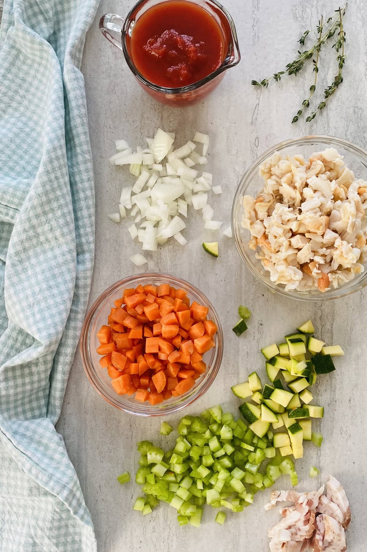 Clams, carrots, celery, zucchini, onion, fresh thyme, crushed tomatoes for a delicious chowder recipe.