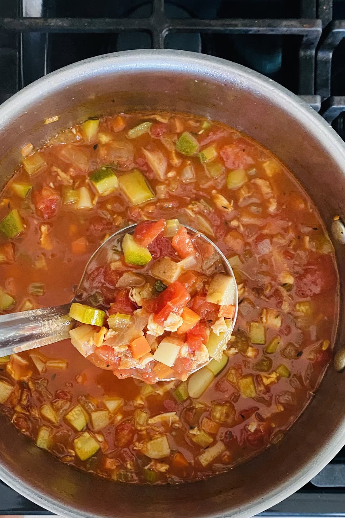 A ladle full with Manhattan clam chowder.