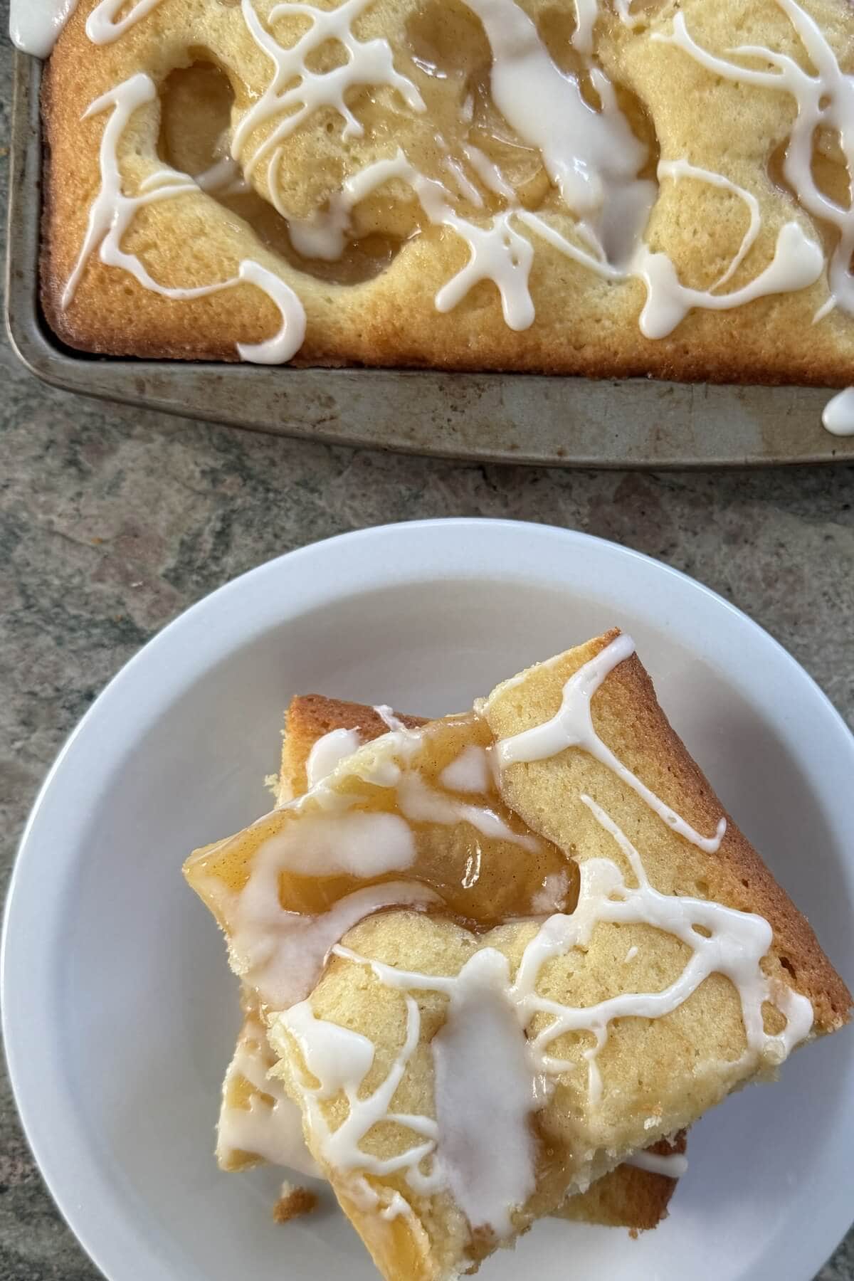 Two slices of scone cake on a plate and the whole cake.
