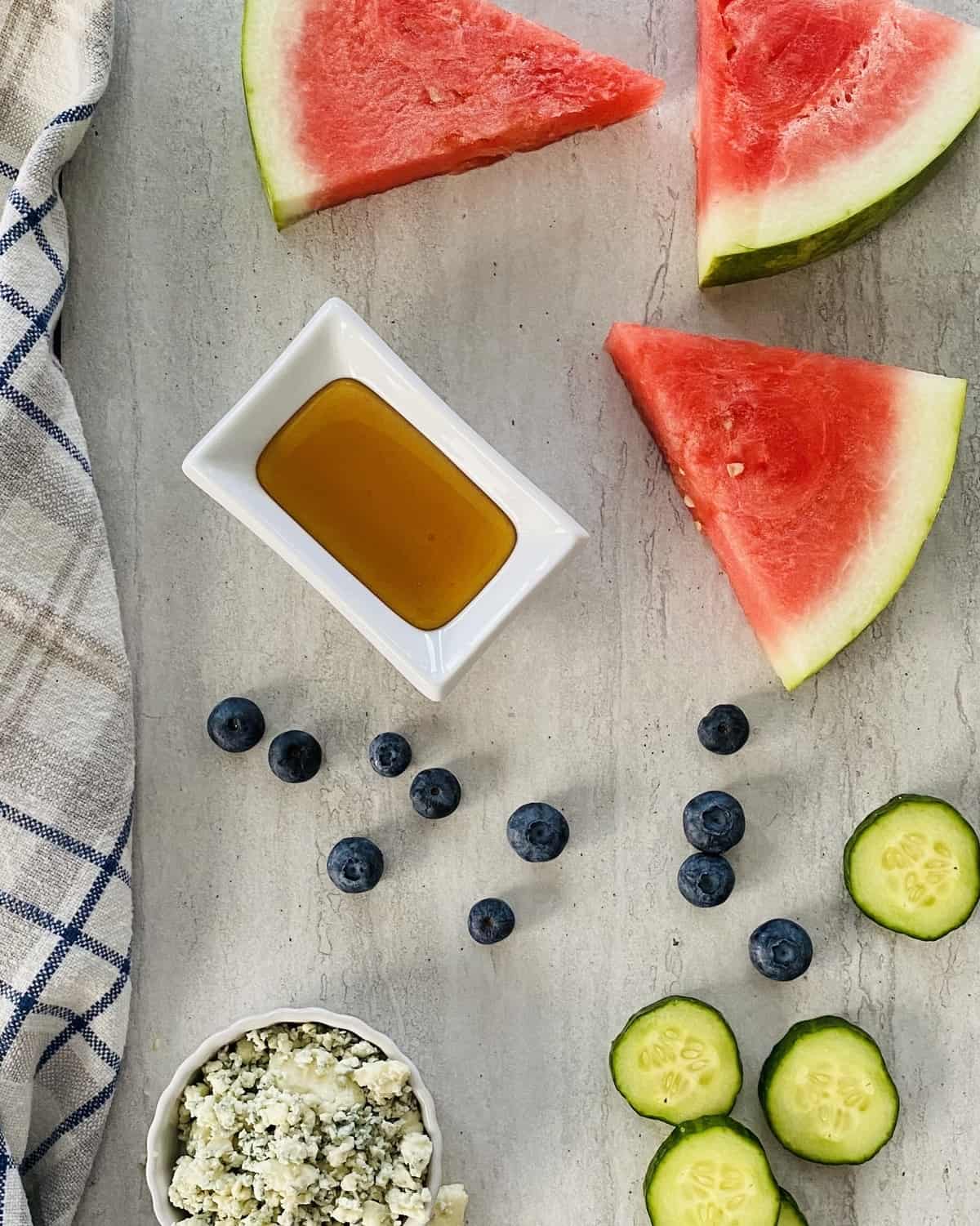 melon wedges, blueberries, blue cheese, cucumber rounds and honey