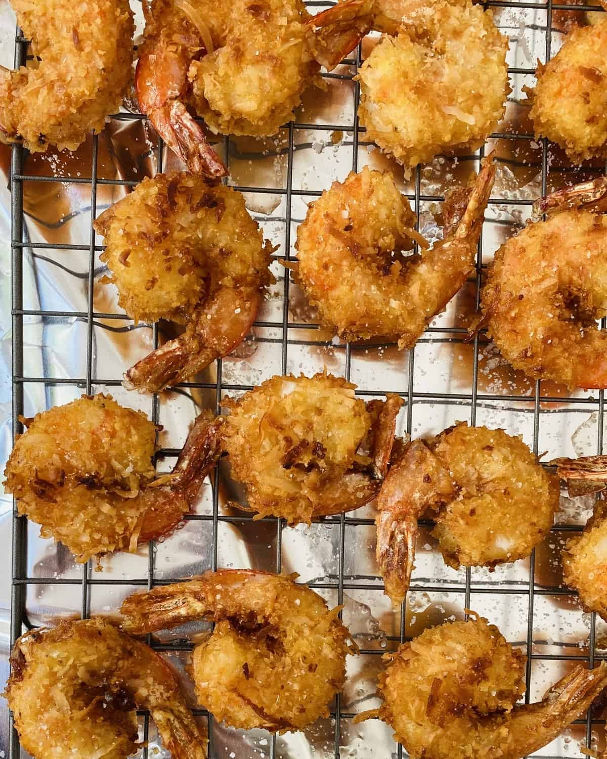 fried coconut shrimp on a cooling rack