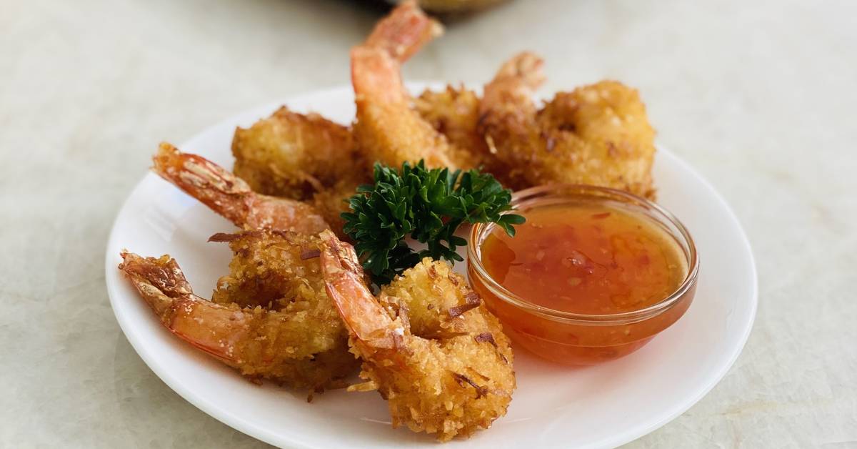 plate of crispy coconut shrimp with dipping sauce