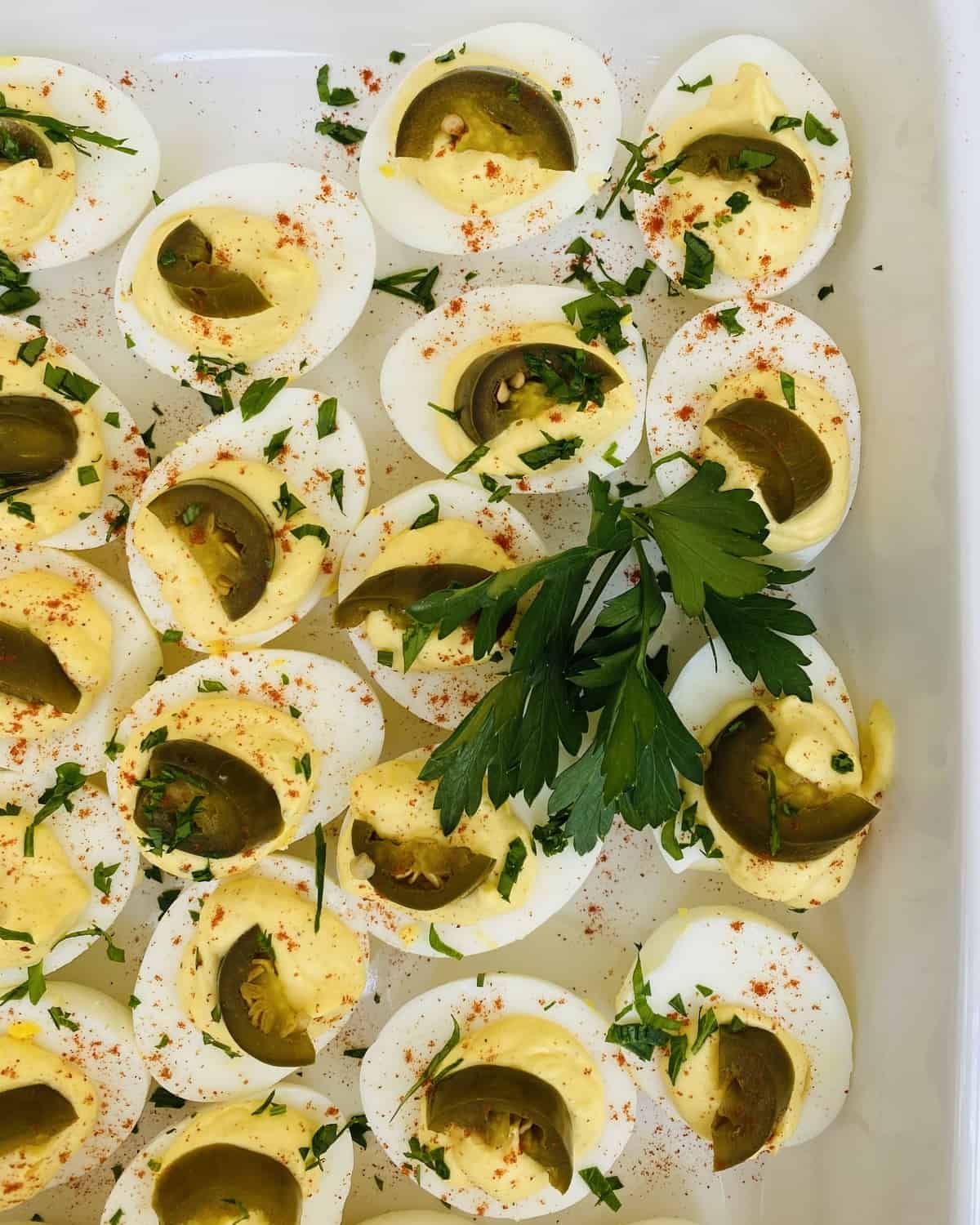 lots of deviled eggs with jalapenos