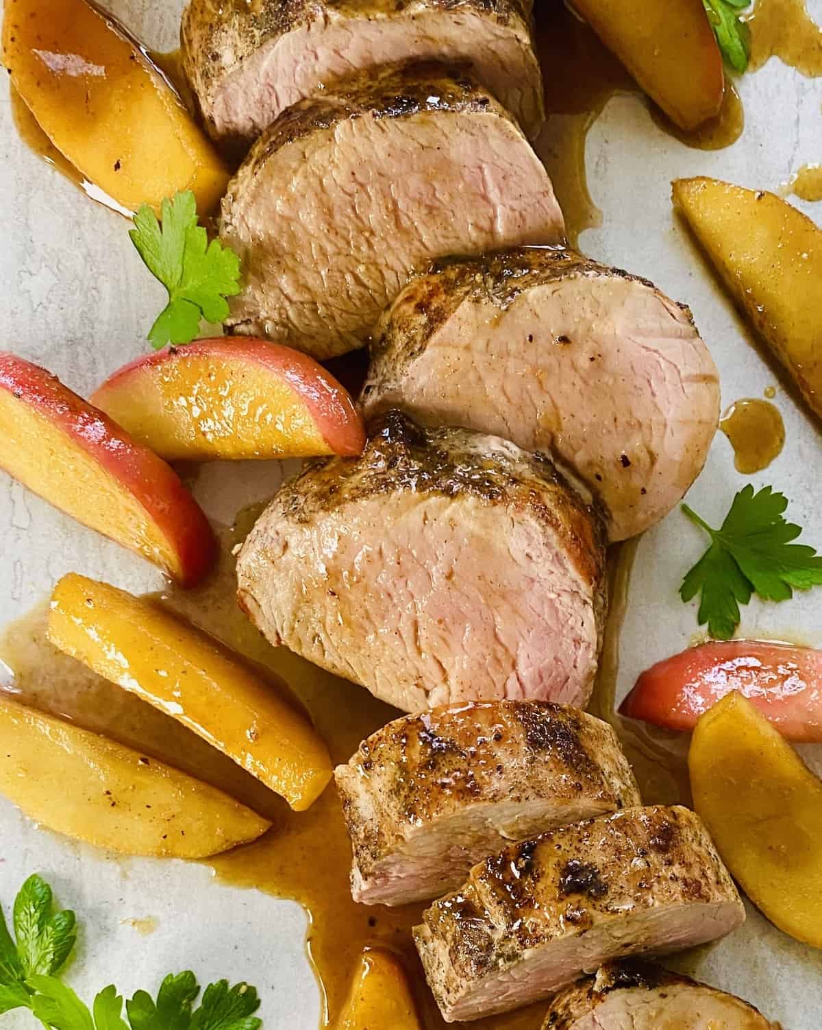 Slices of maple glazed pork tenderloin with sauteed apples.