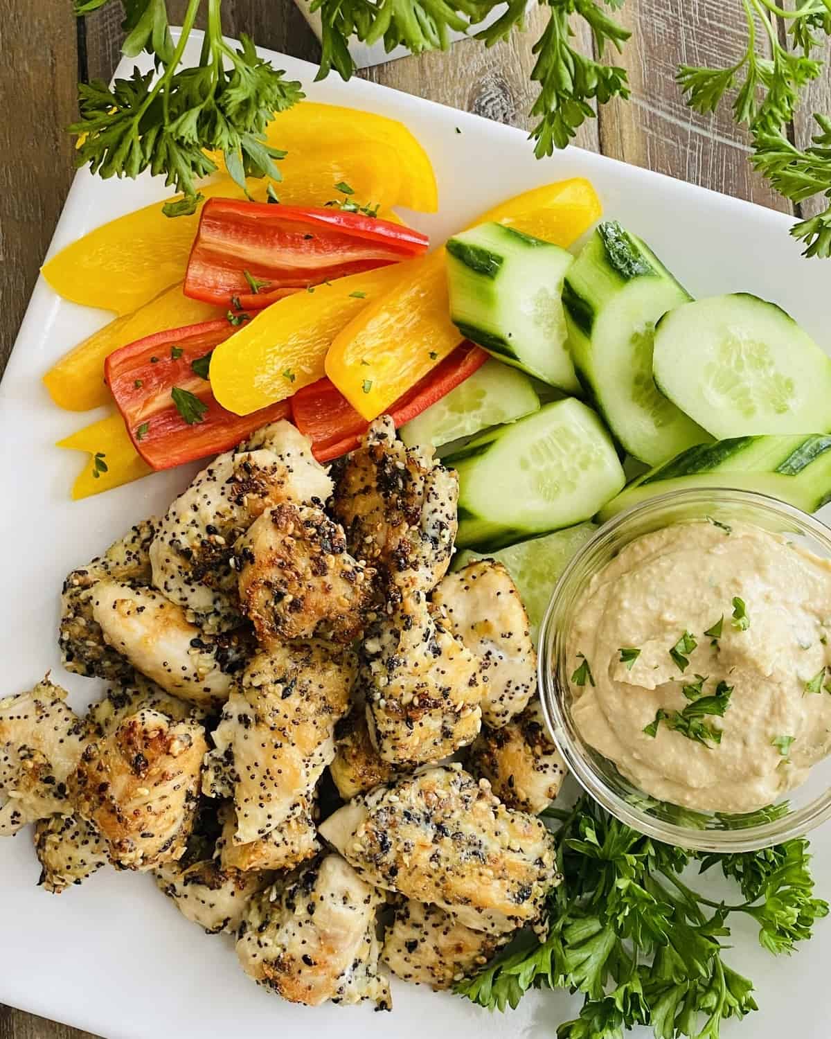 platter with chicken bites, hummus, cucumber slices and bell peppers