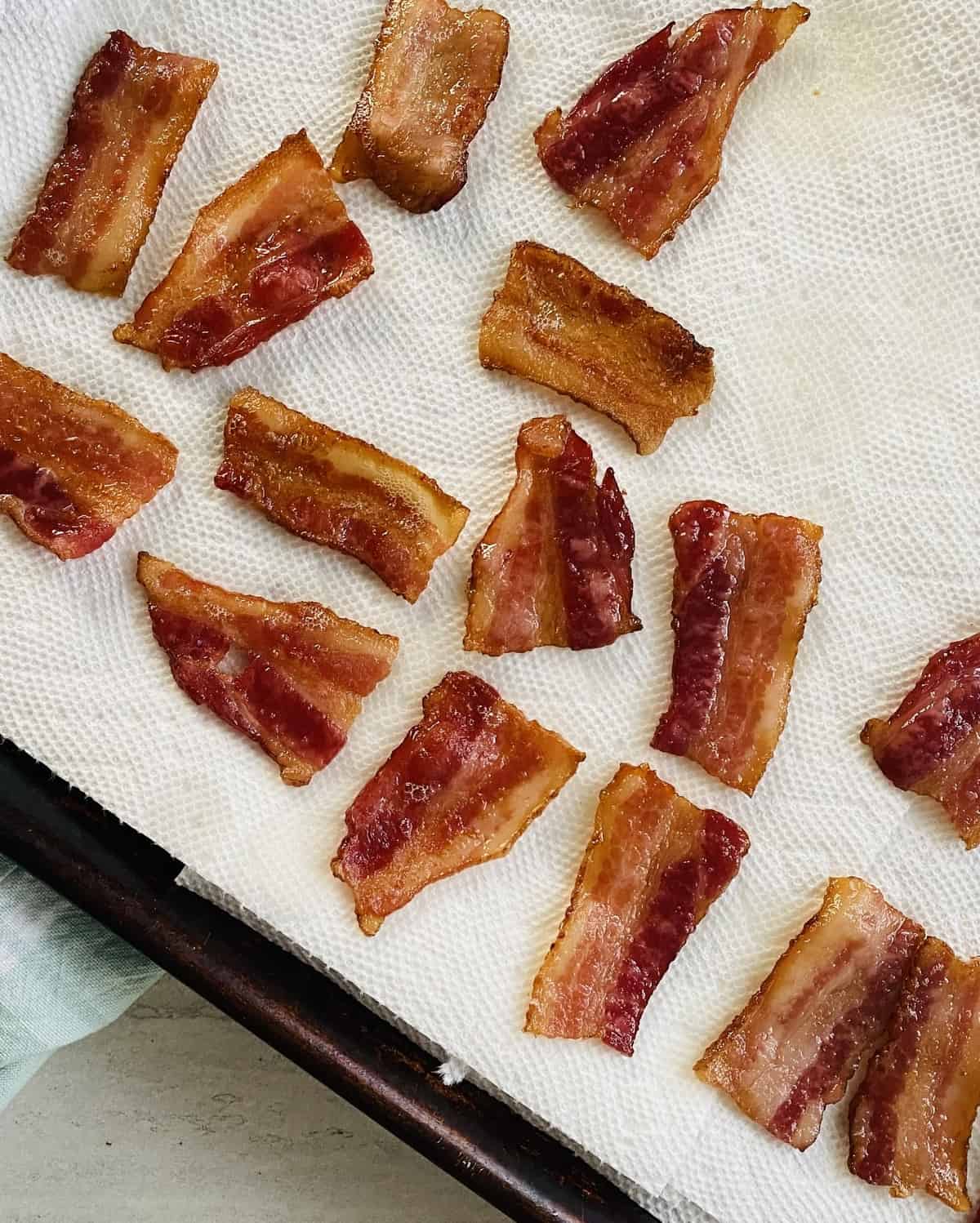 Draining grease of small pieces of bacon on paper towels.