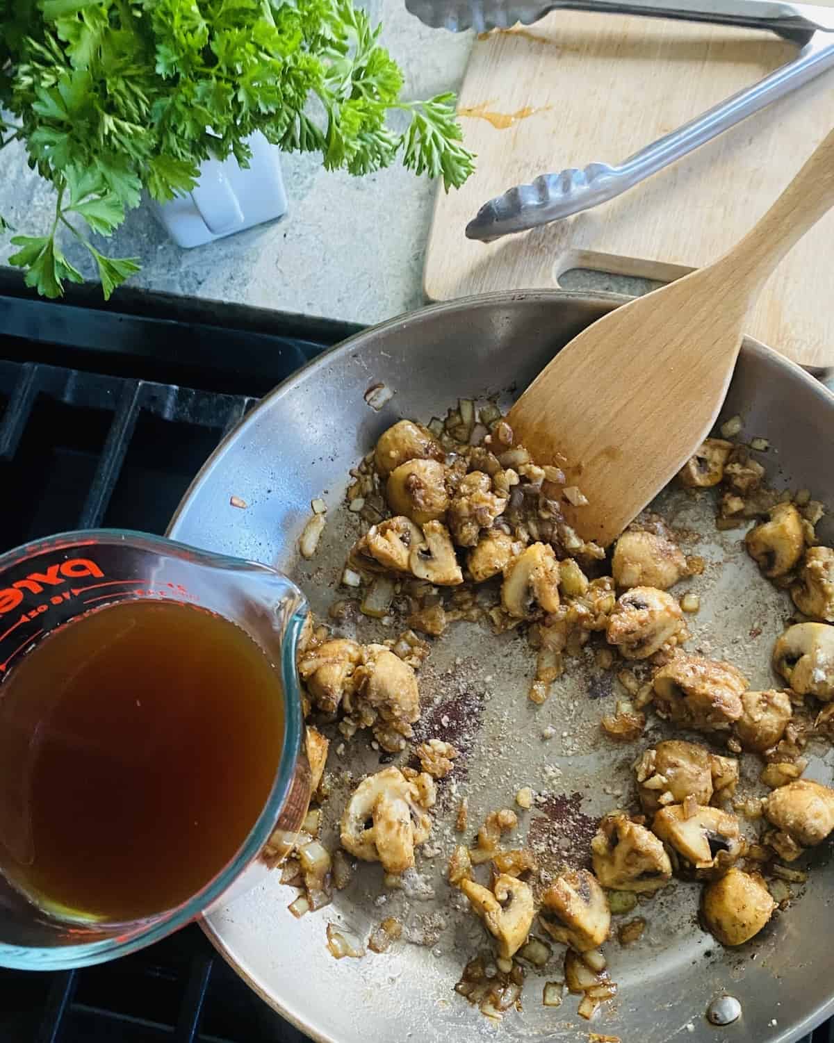 Adding beef stock to sauté pan.