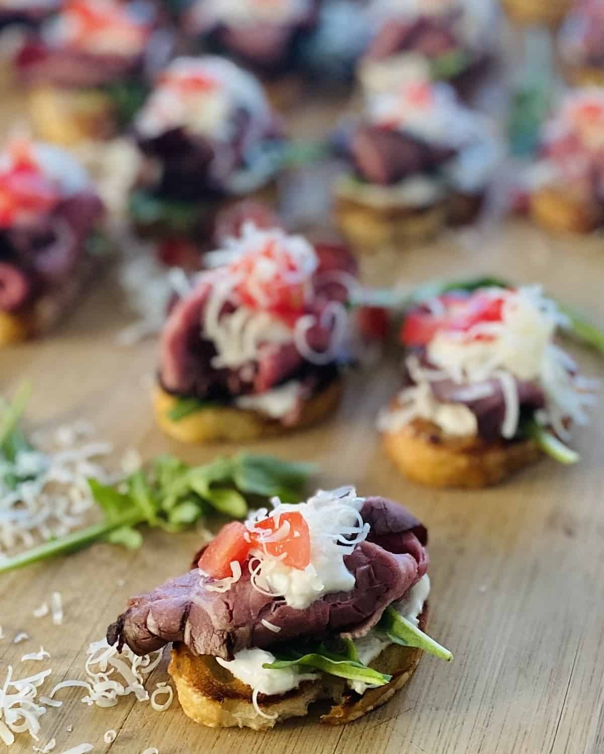 cutting board toasted bread topped with sour cream horseradish and shredded cheese