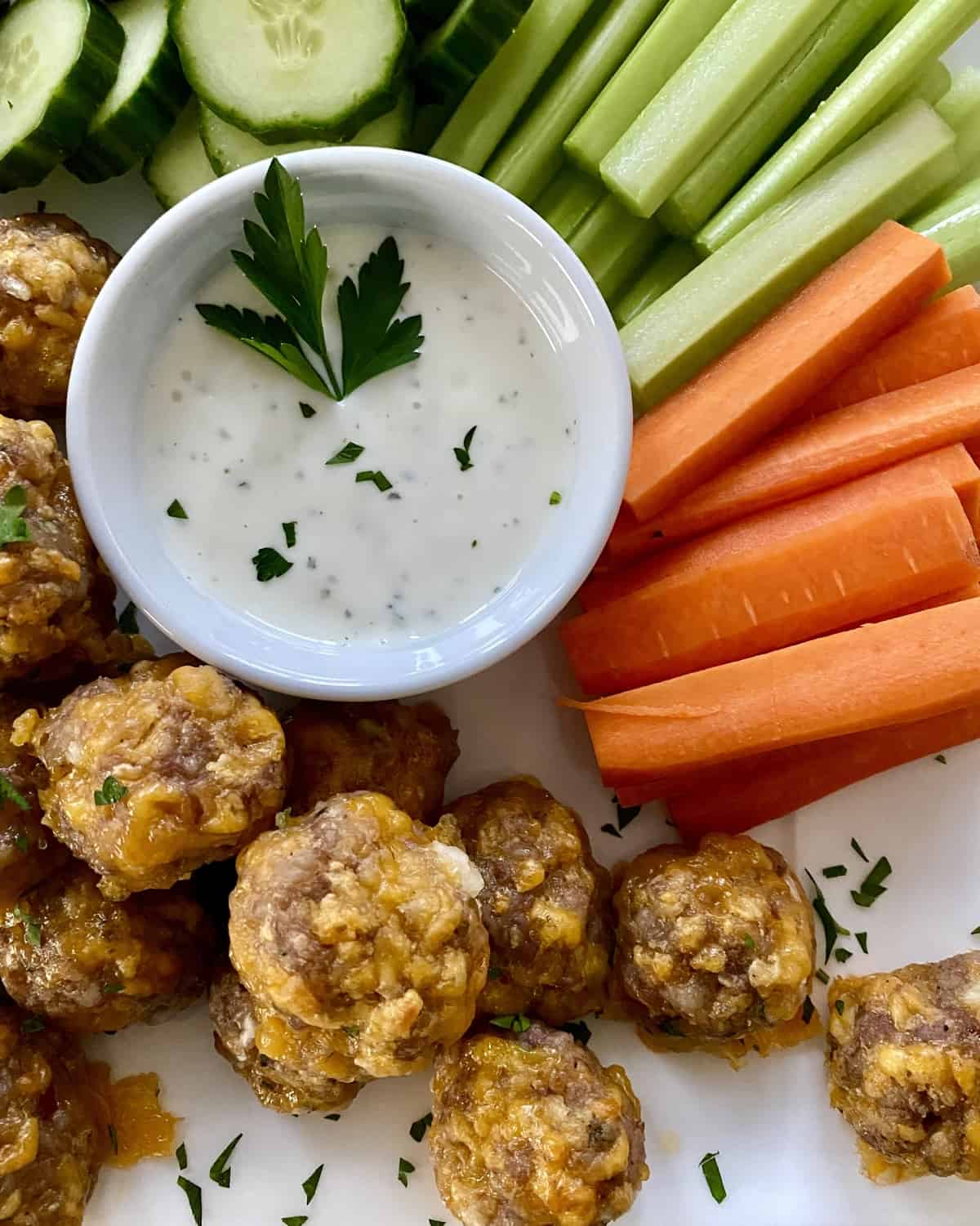 Sausage cheese balls on a platter with carrots and dip