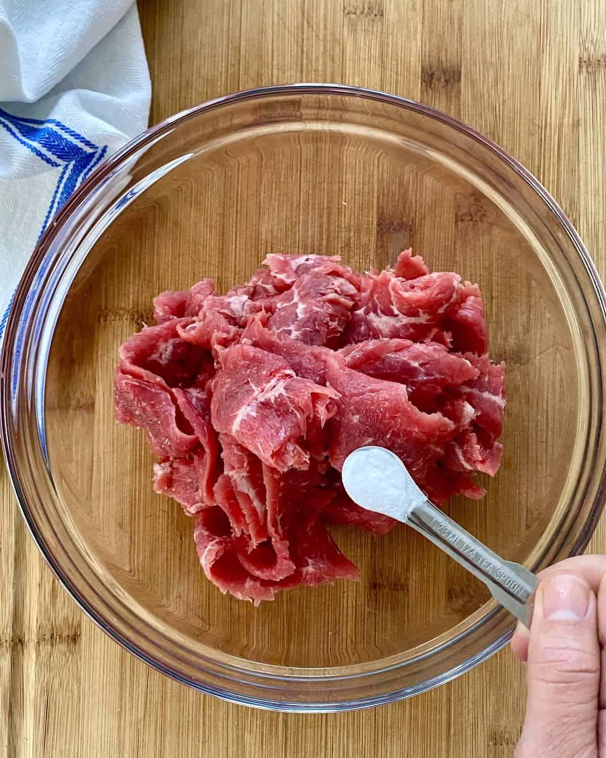 adding baking soda to sliced steak