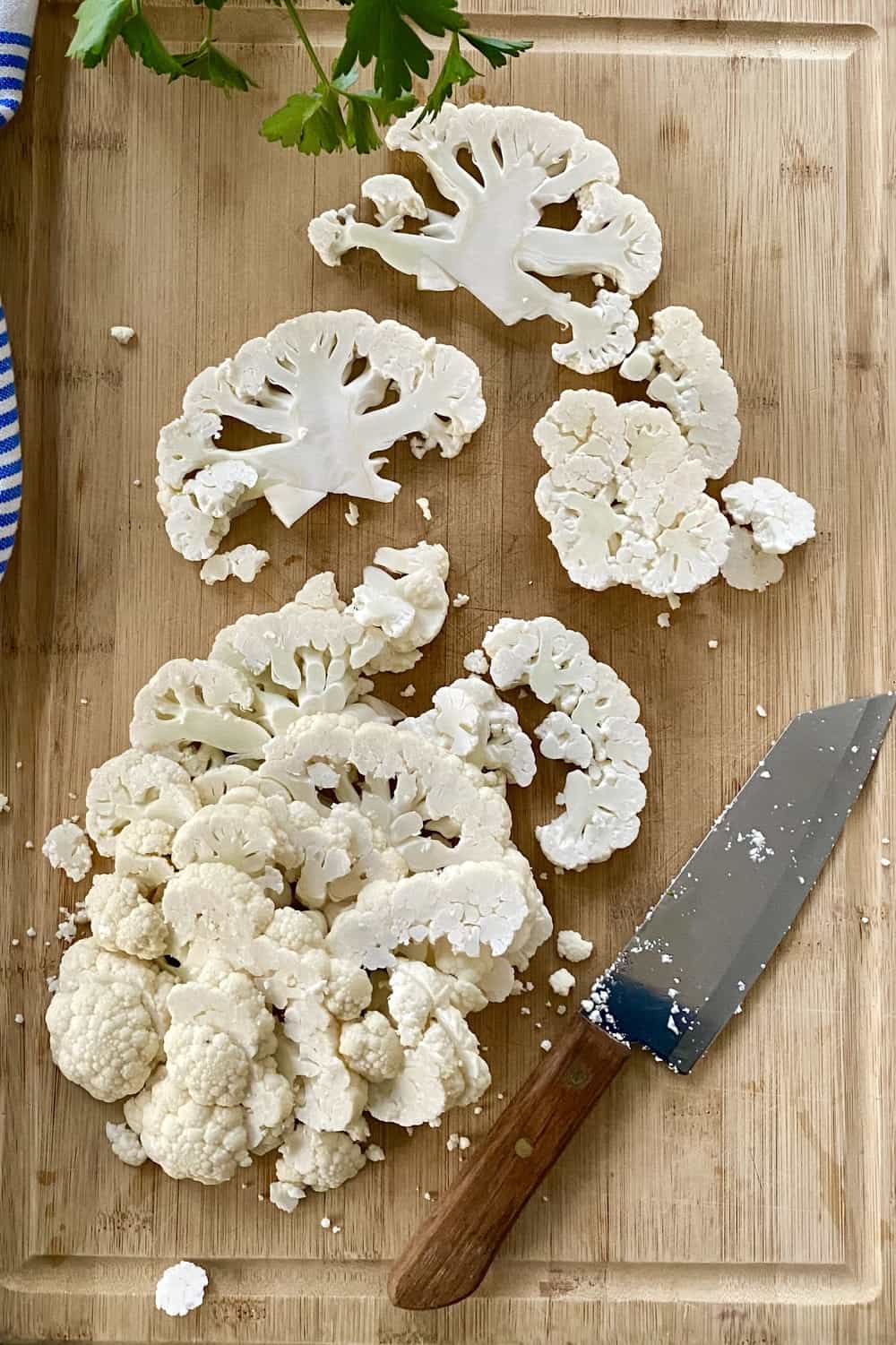 slice cauliflower on a cutting board with a knife