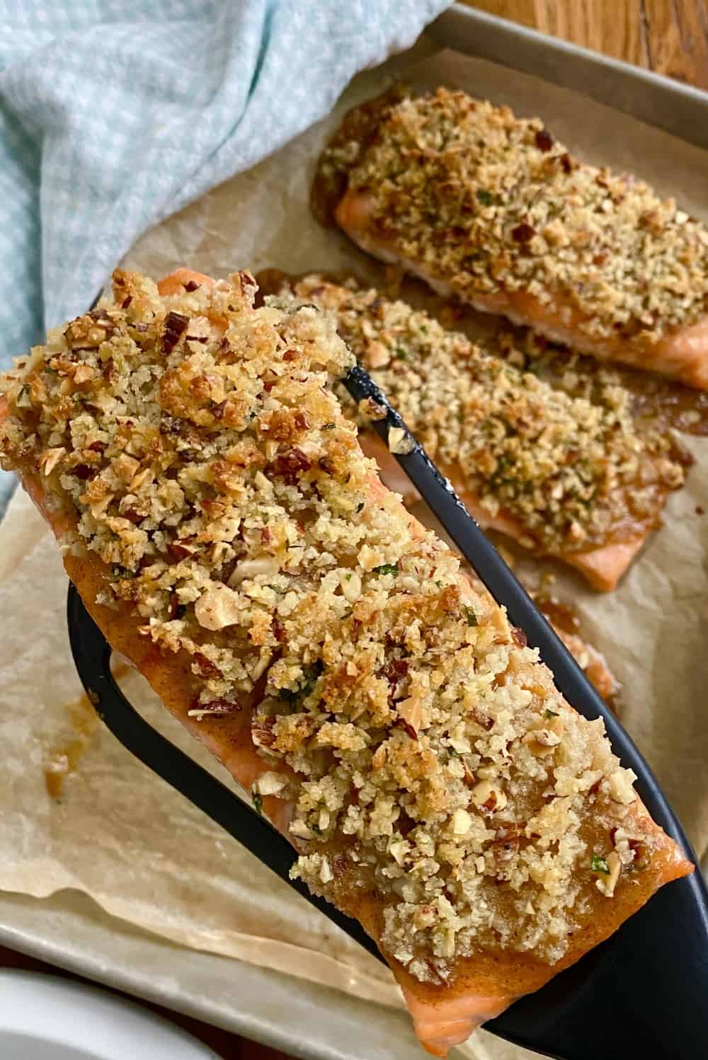 Baked pecan crusted salmon on a spatula.