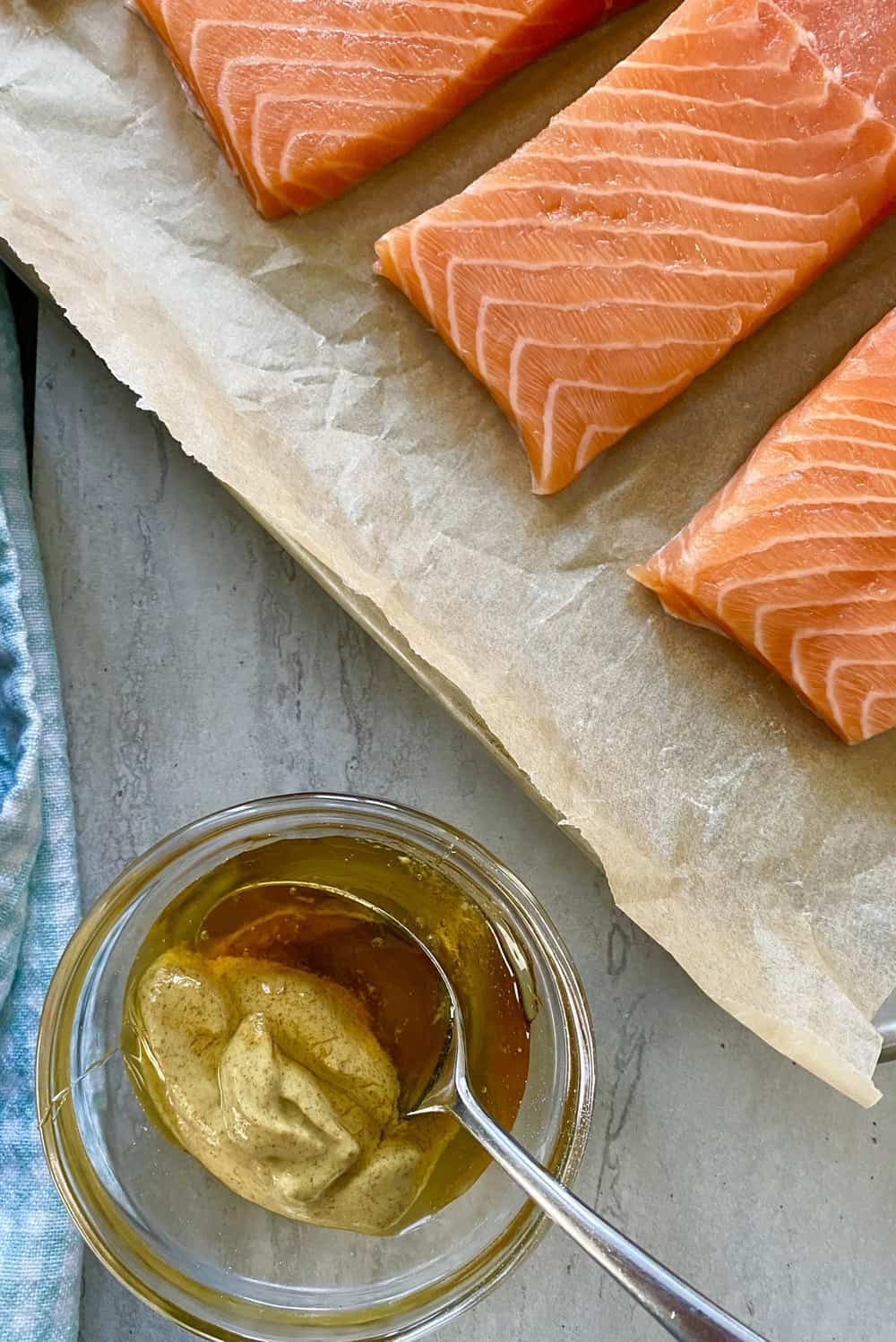 Mixing honey and Dijon mustard in a bowl and raw salmon.