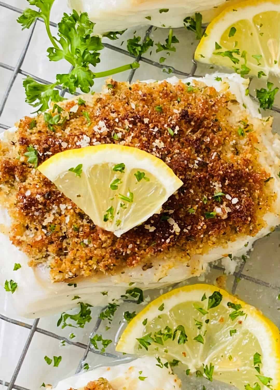 Fish with a crumb topping and a lemon slice.