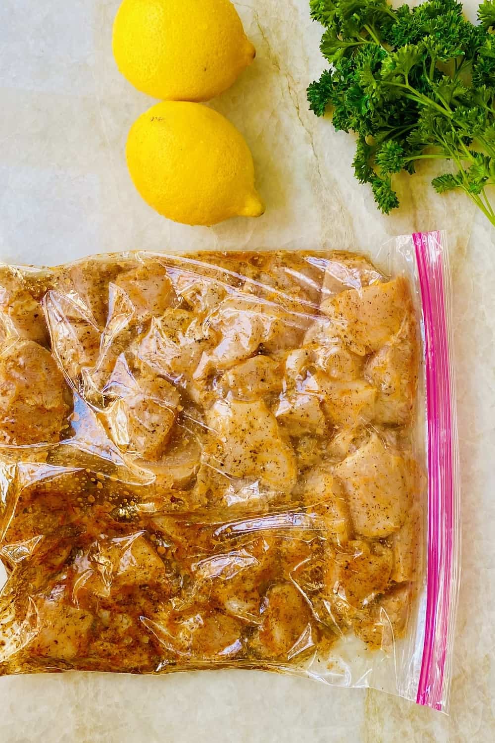 Marinating lemon herb chicken in a ziploc bag.
