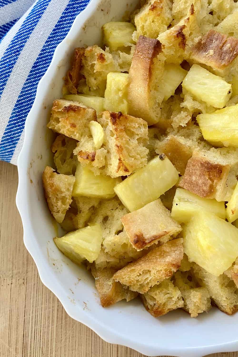 A dish of baked bread pudding with pineapple.