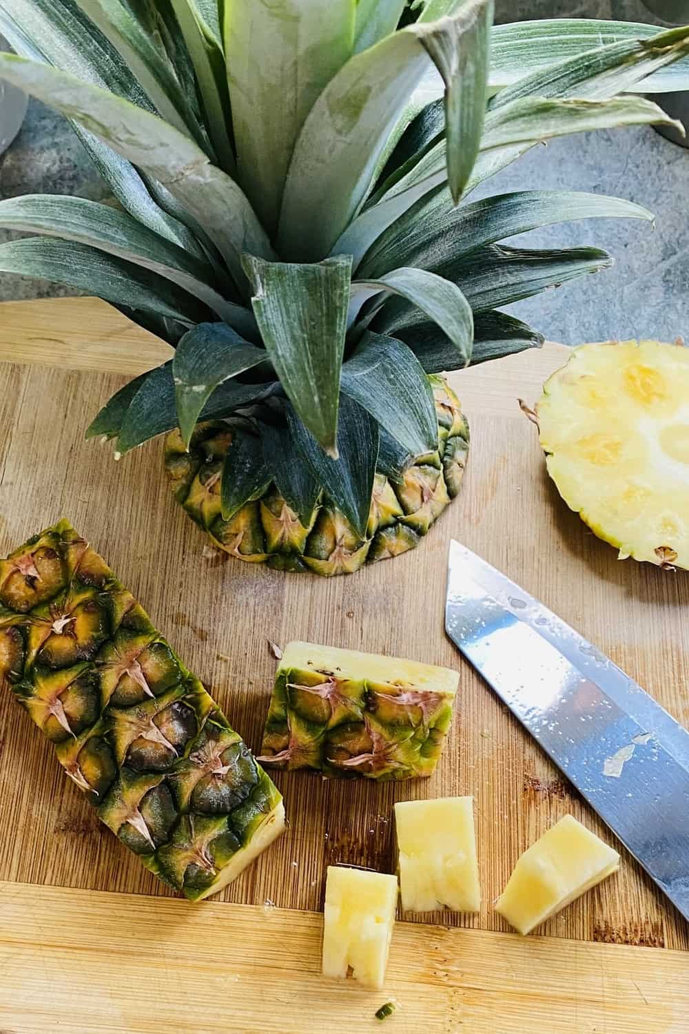 A cut up fresh pineapple on a cutting board.