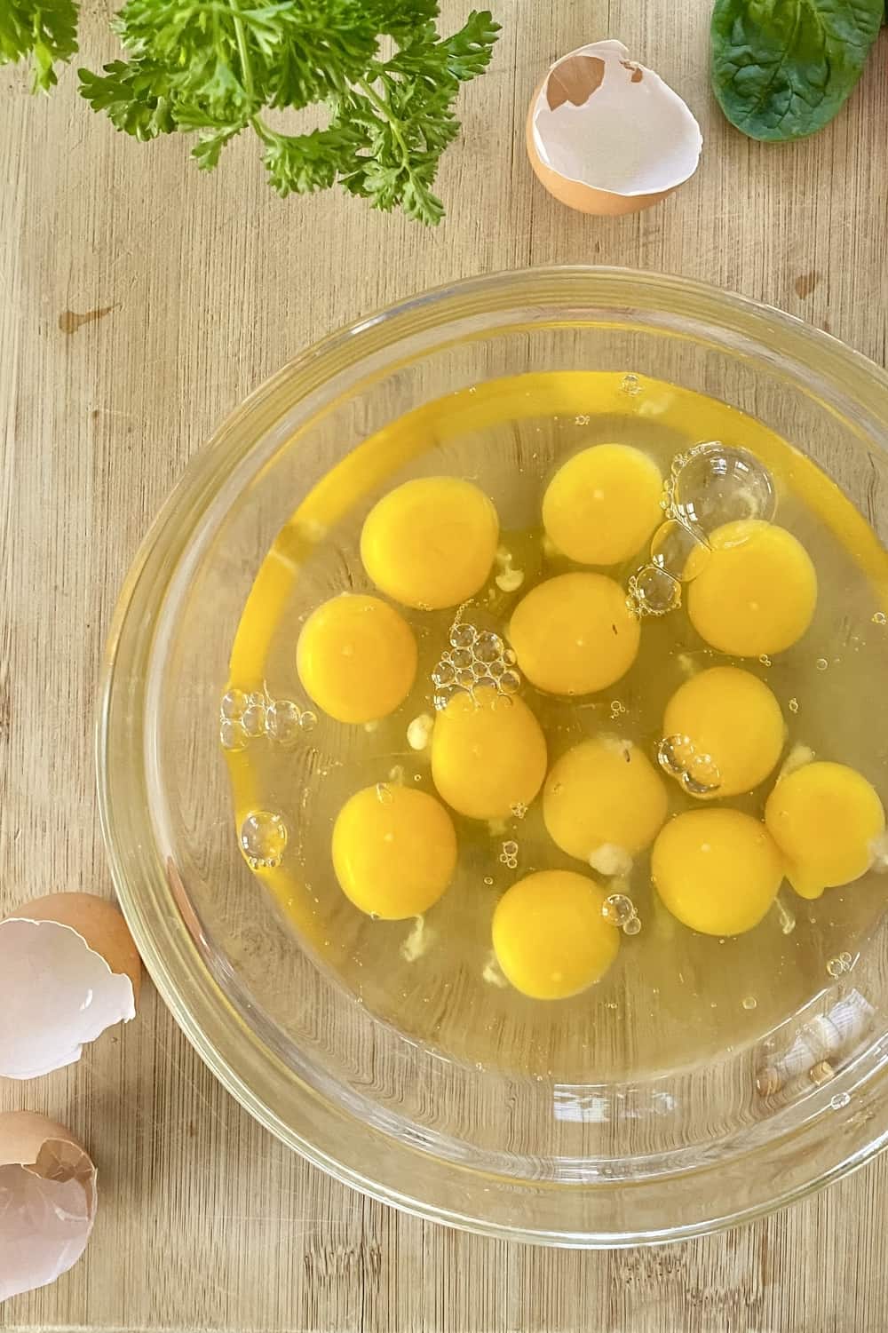A large bowl with cracked eggs in it.