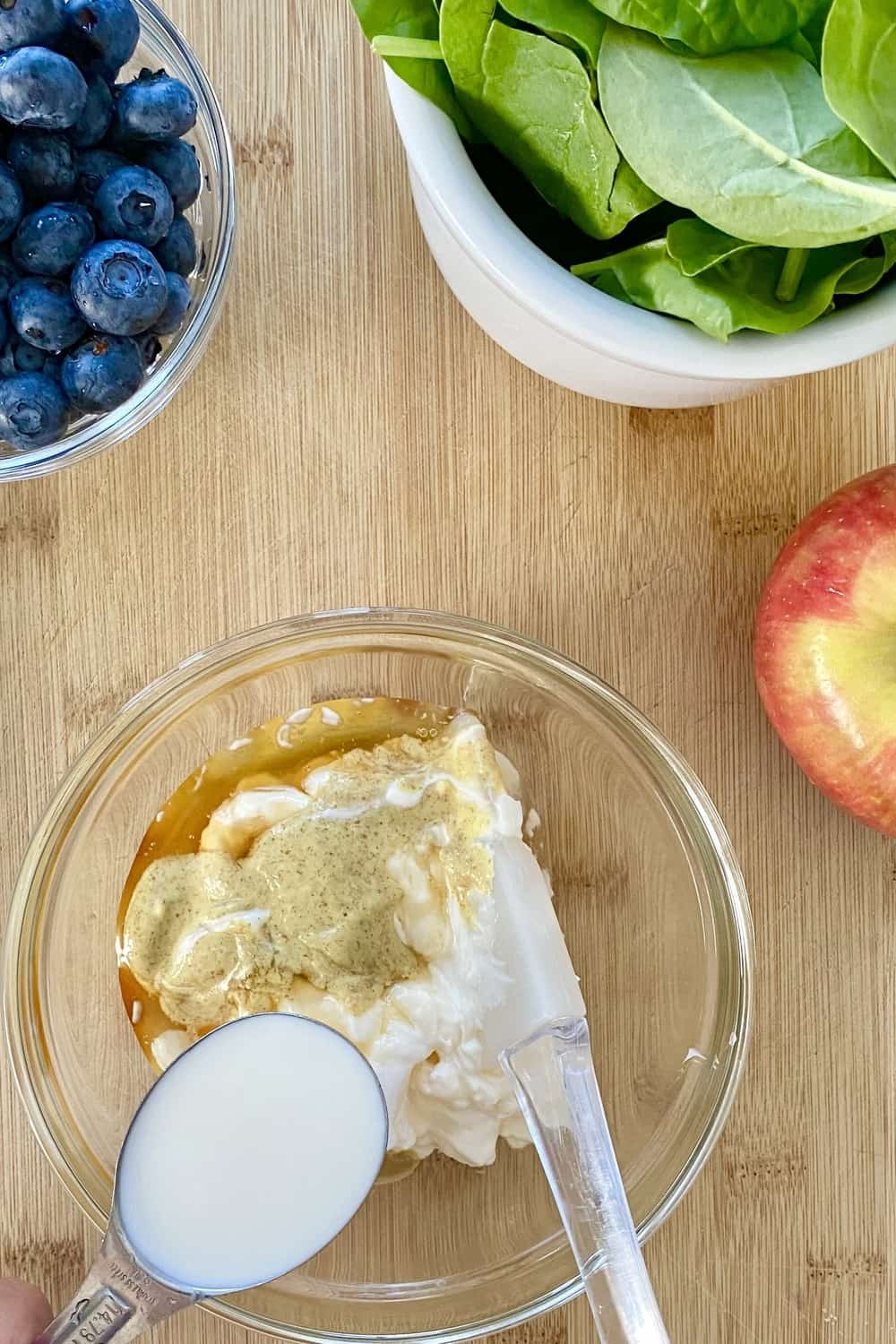 A small bowl with yogurt dressing ingredients.