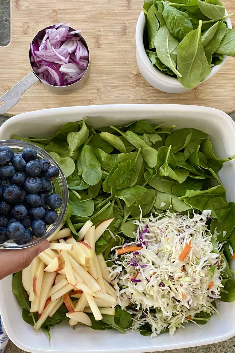A large bowl with spinach, cabbage, and blueberries.