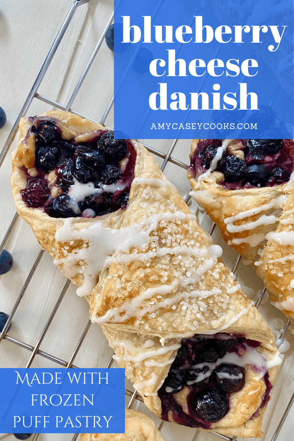 2 blueberry danish on a cooling rack with icing.