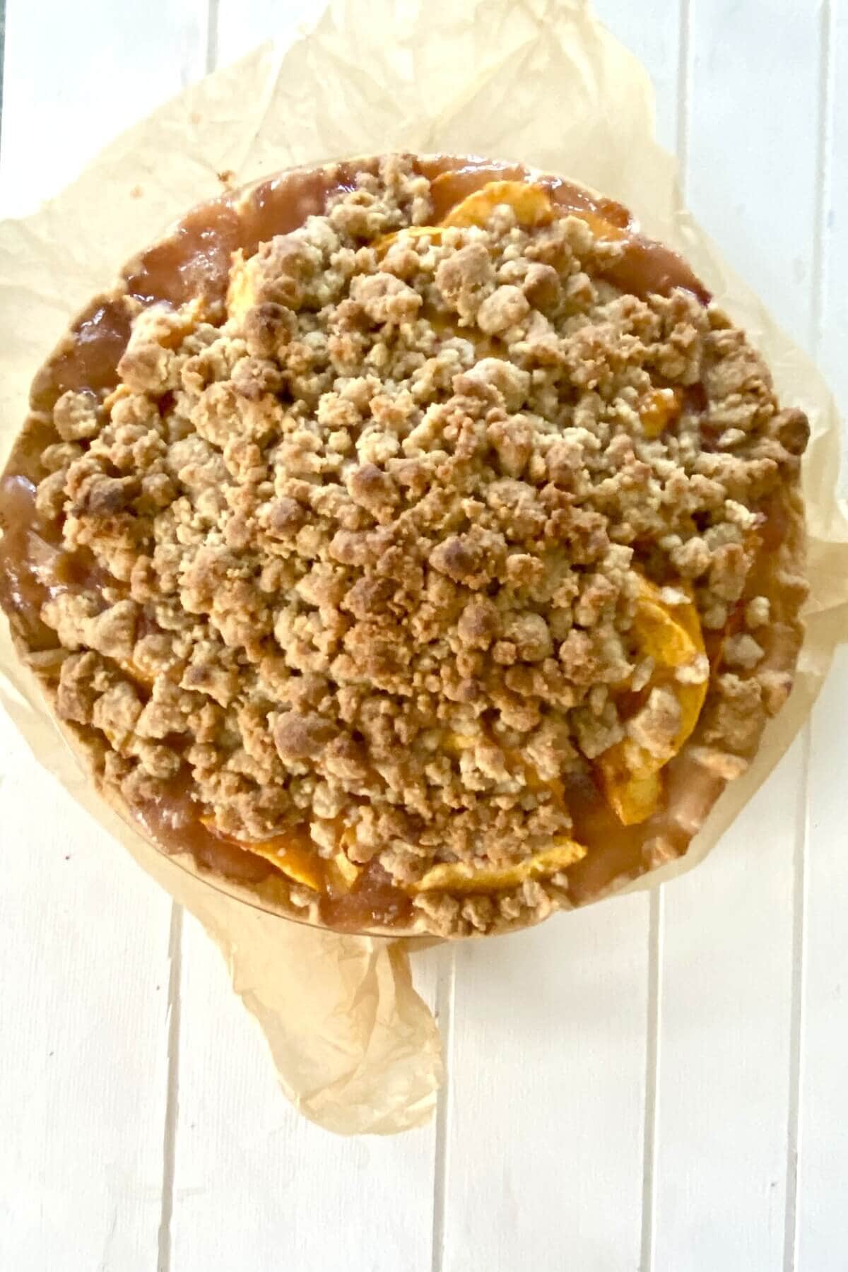 A baked peach crumble pie.