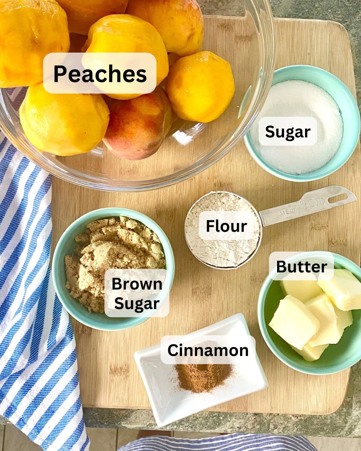 Fresh peaches, butter, flour, sugar, cinnamon, and brown sugar on a cutting board.